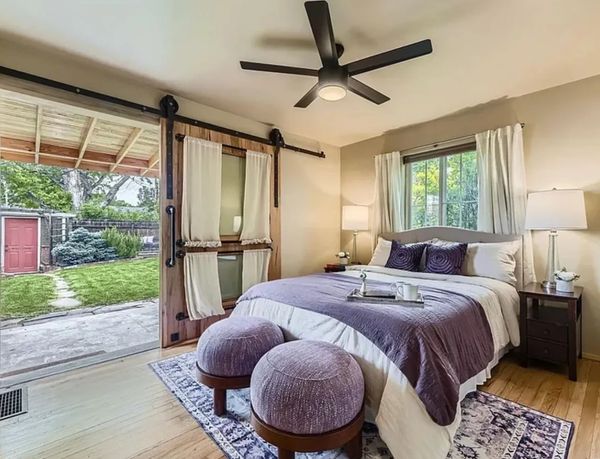 Gorgeous bedroom with purple accents and a large barn door to backyard