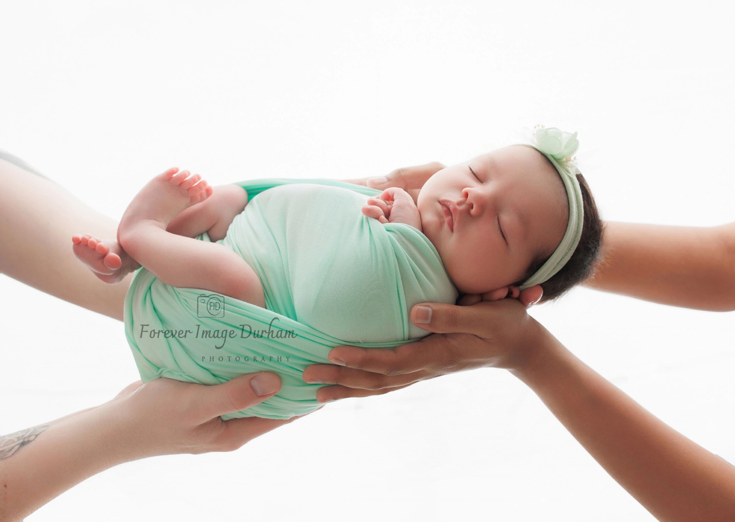 Newborn baby peacefully sleeping, gently cradled in loving hands.