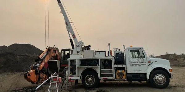 Mobile mechanic servicing heavy equipment at job site field repair. On-site diesel mechanic service.