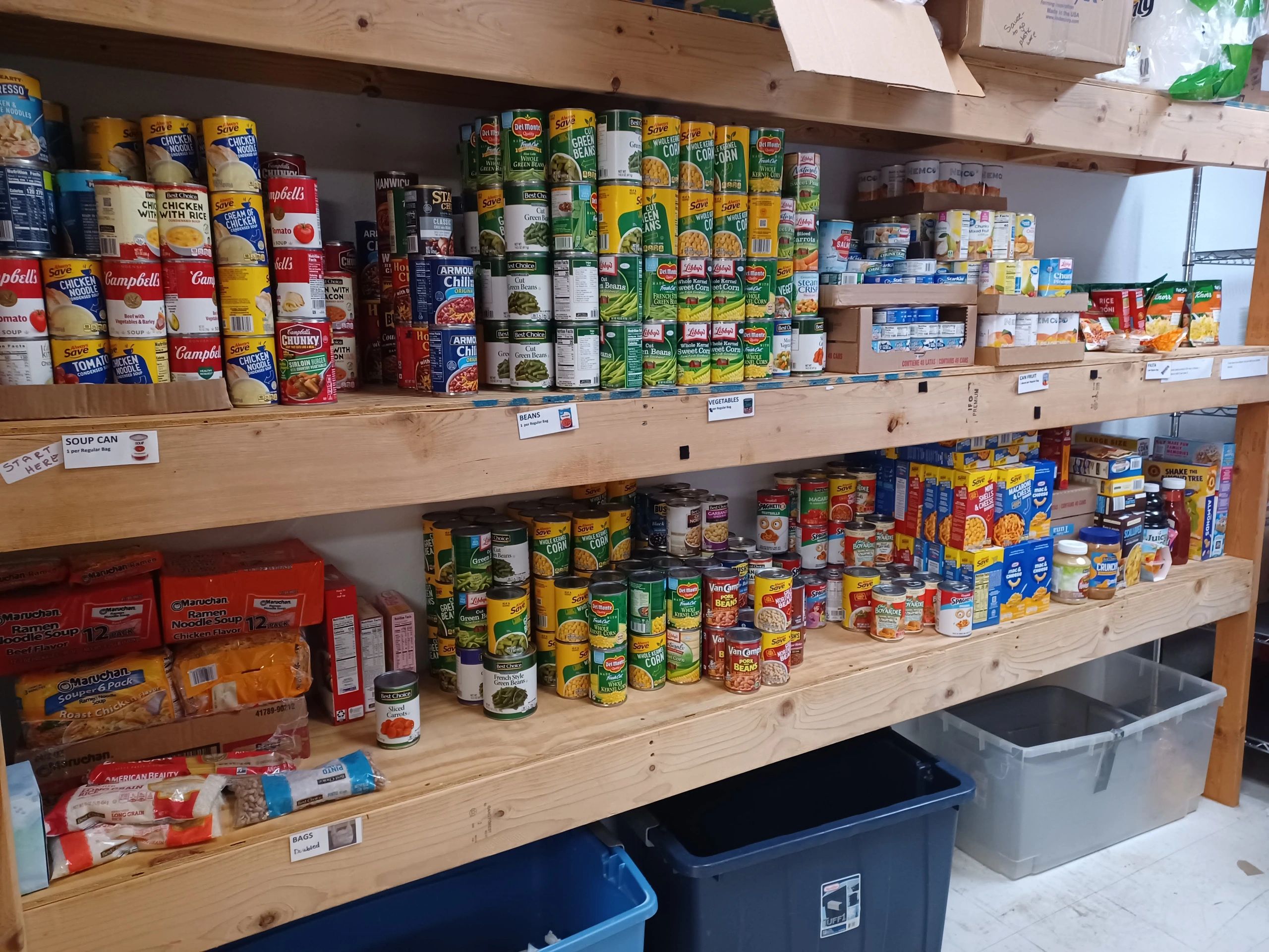 Organized shelves stocked with canned goods and dry food in a pantry.
