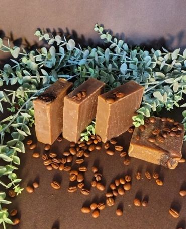 Handmade coffee soap bars with coffee beans and eucalyptus leaves.