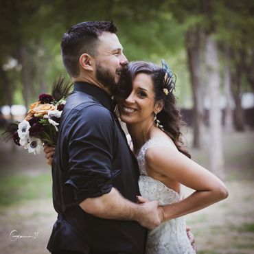 Happy couple embracing on their wedding day outdoors.