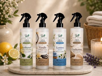 Quatre flacons de parfum d'ambiance sur un plateau en marbre.
