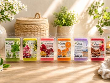 Sept savons parfumés colorés alignés sur une table en bois.