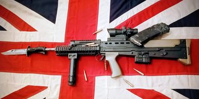 A tactical rifle with a bayonet and ammo on a British flag.