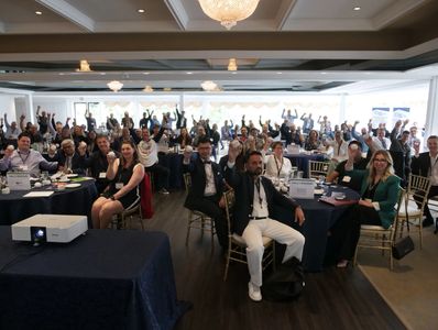 Group of people at a conference waving hands.