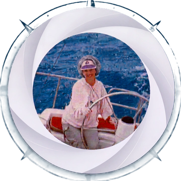 Woman steering a sailboat on the ocean.