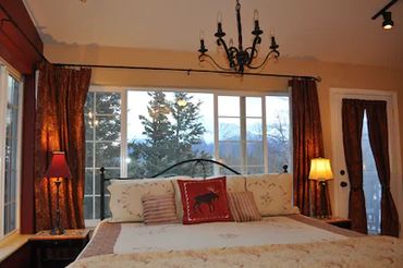 View of trees from the window of a bedroom