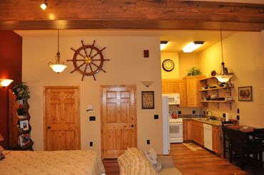 View of a room with an attached kitchen and two doors