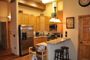a small kitchen with a refrigerator and lights on