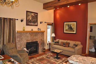 a living room with a fireplace, sofa, and more