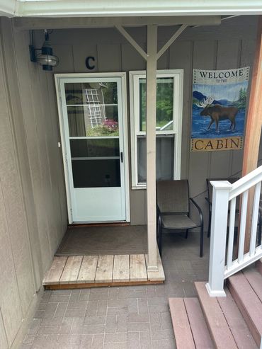 An entrance of a house with a Welcome to The Cabin Banner