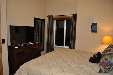 A Bedroom with LED TV and a Small Window