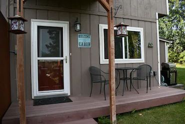 A patio with two metal chairs and a small table
