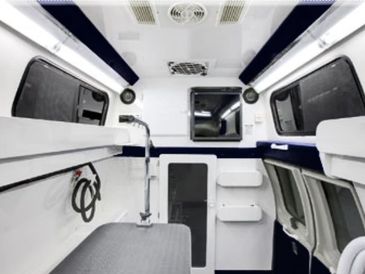 Interior of a modern ambulance with medical equipment and padded surfaces.