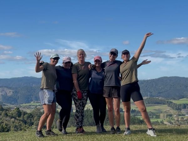 Gardening ladies in a group photo. Standing on a hill looking happy. Team photo in mountains, sunny