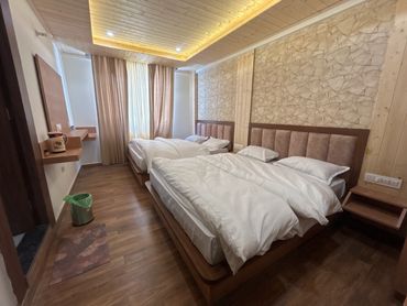 Cozy twin bed room with wooden accents and warm lighting.