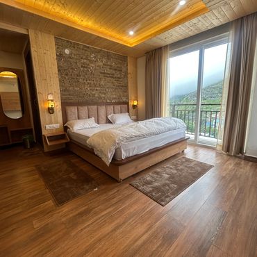 Cozy wooden bedroom with a large bed and a scenic view.