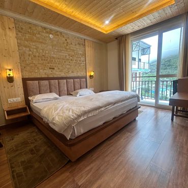 Cozy wooden bedroom with bed and large window.