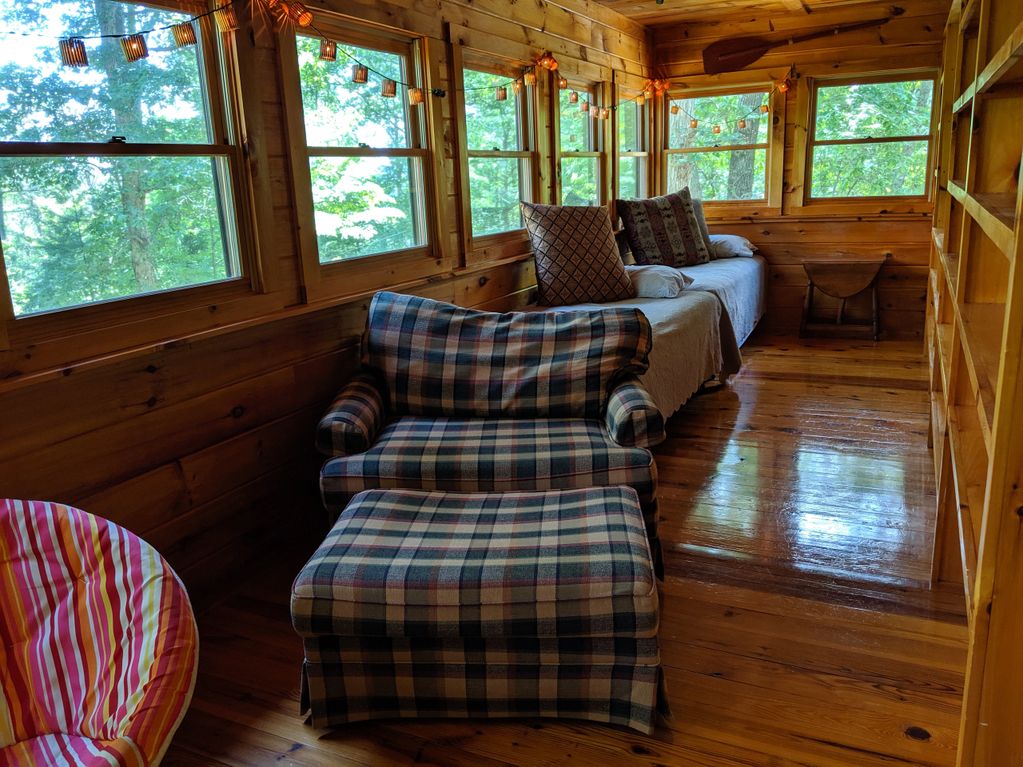 A picture of the chairs and bed inside the wooden house