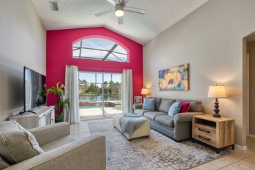 Disney Lillian House family room with furniture overlooking the pool, hot tub and resort lake view