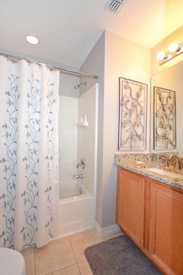 Disney Lillian House ensuite queen bedroom with attached bath, shower, tub and vanity