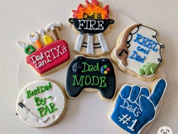 Decorated cookies celebrating dad with playful messages and designs.
