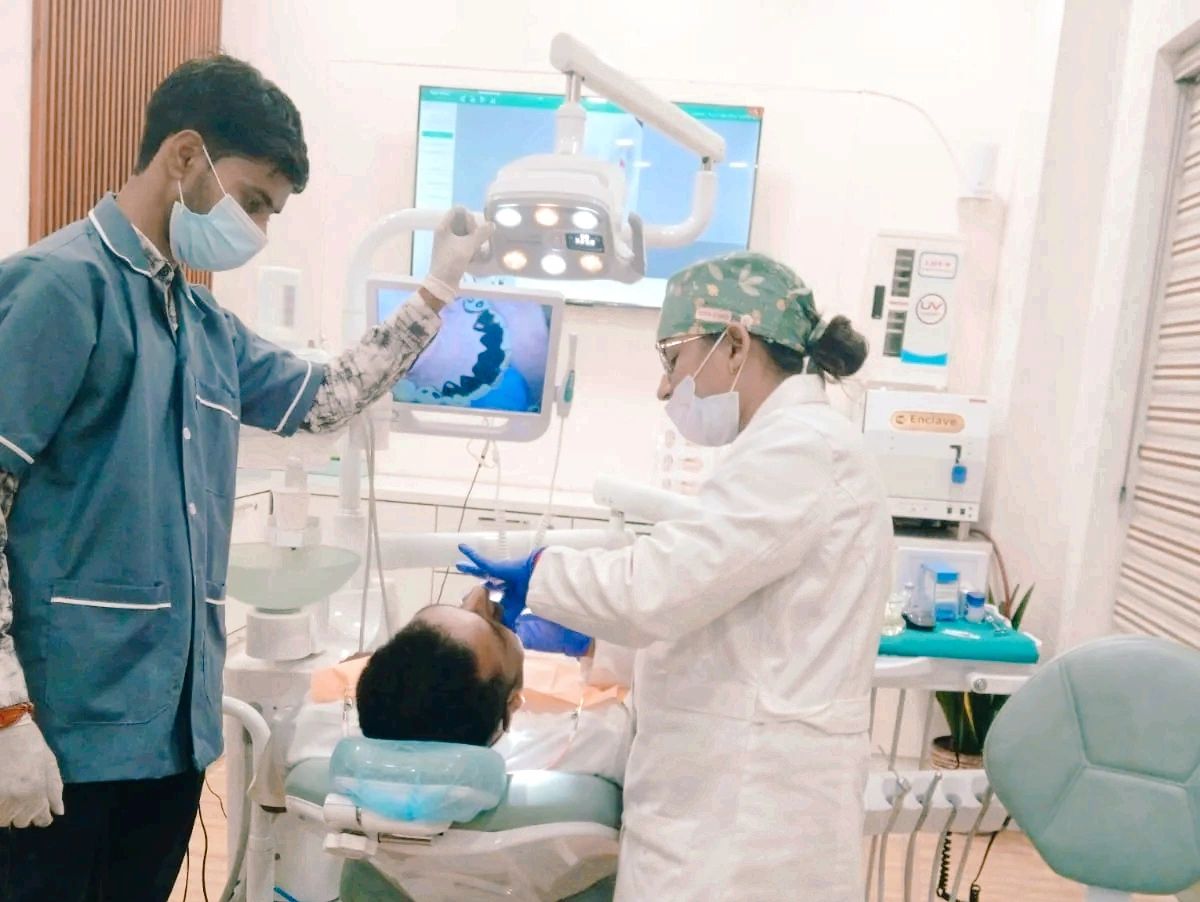 Dentist and assistant treating patient in dental clinic.
