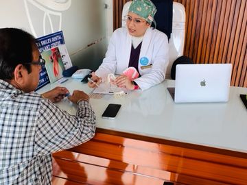 Dentist consulting a patient with dental models at a modern clinic.