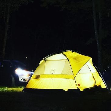 Yellow tent glowing in the dark night