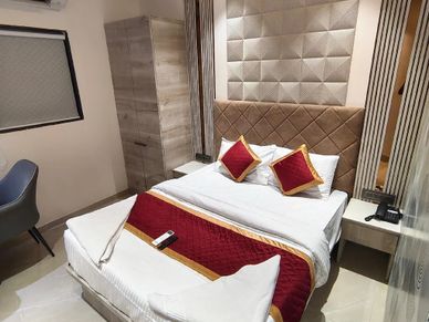 Modern bedroom with a cozy bed and red accents.