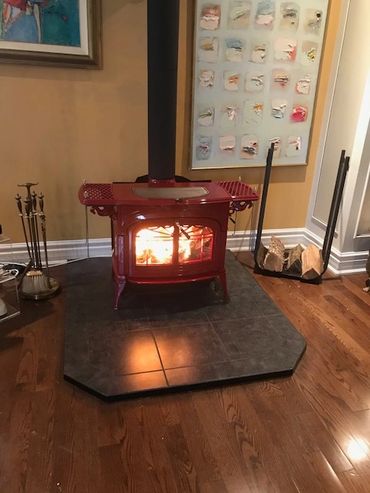 large wood stove
hearth pad
wood
chimney
installation
near Kawartha Lakes