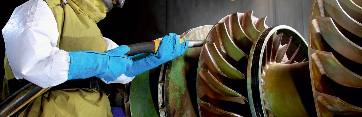 picture of a person shotblasting a machine part