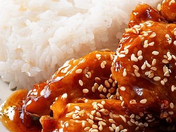 Glazed sesame chicken served with white rice.