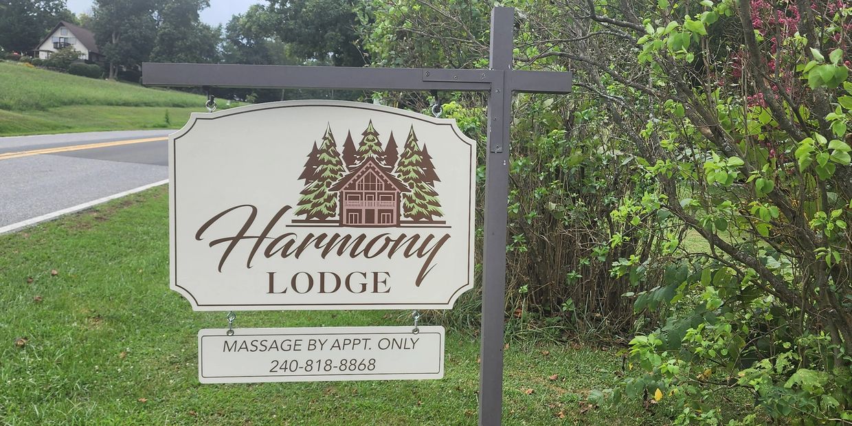 Sign for Harmony Lodge offering massages by appointment.