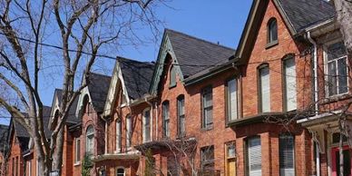 Row of brick townhouses under a clear sky.