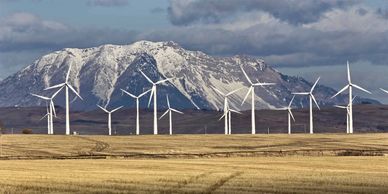 Wind turbines in front of snowy mountains