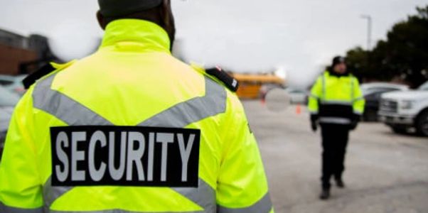 Security personnel in bright yellow jackets managing a parking area.