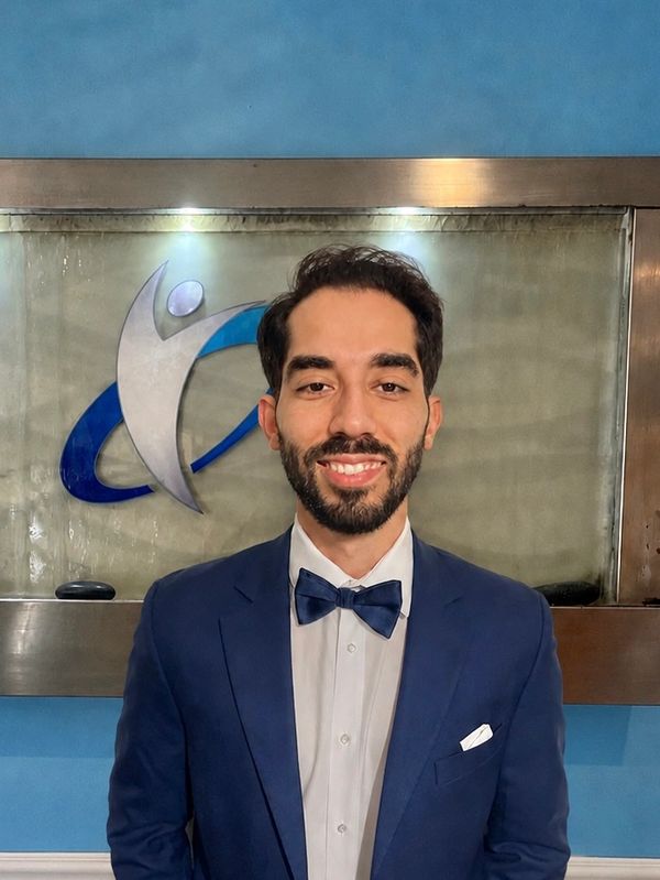 Man in blue suit and bow tie smiling.