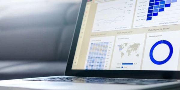 Laptop displaying data analytics charts and graphs on screen.