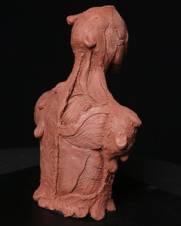 A creature maquette sculpted out of Chavant clay to show a melting man with exposed muscles