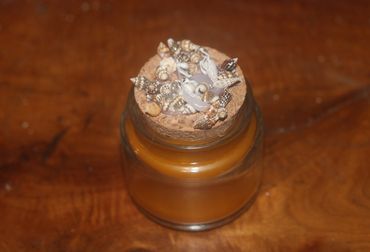 Jar sealed with a cork and small decorative seashells.