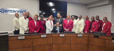 Group of men in red and white suits around a conference table.