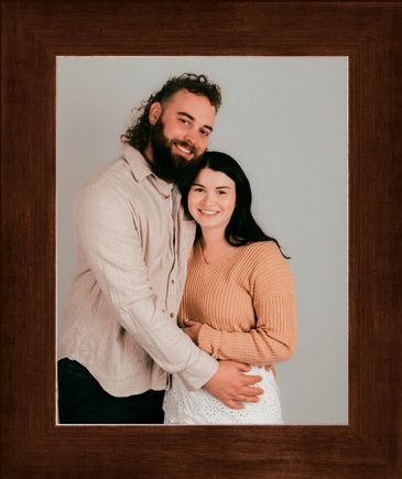 Couple embracing and smiling in a framed photo.