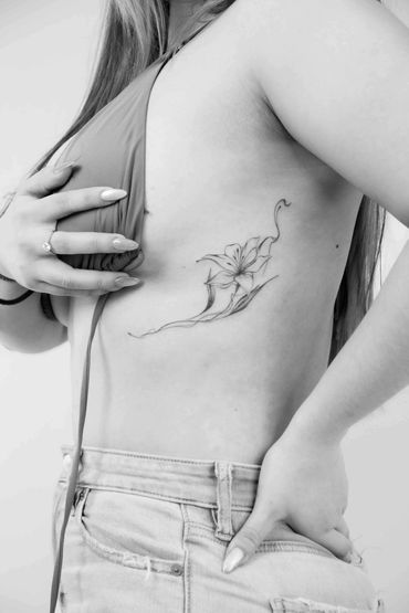 Fine line floral ribs tattoo