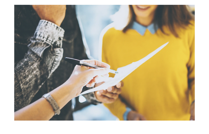 People discussing a divorce document with a pen pointing at it.