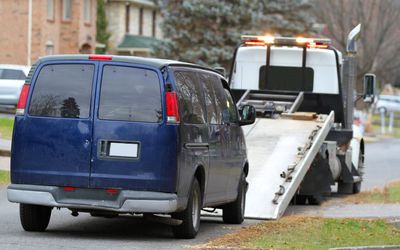a rollback tow truck loading up a van for removal in Vancouver