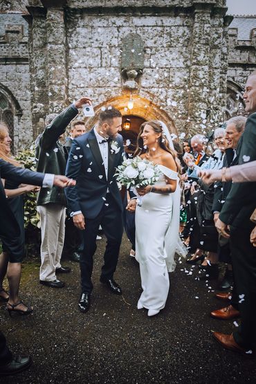 Candid confetti shot of bride and groom