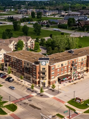 Aerial view of a suburban intersection with commercial and residential buildings.