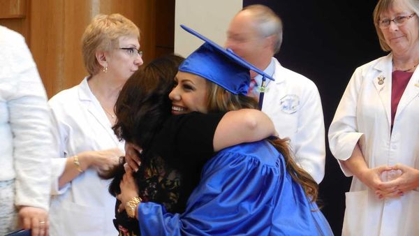 A fresh graduate hugging her mother